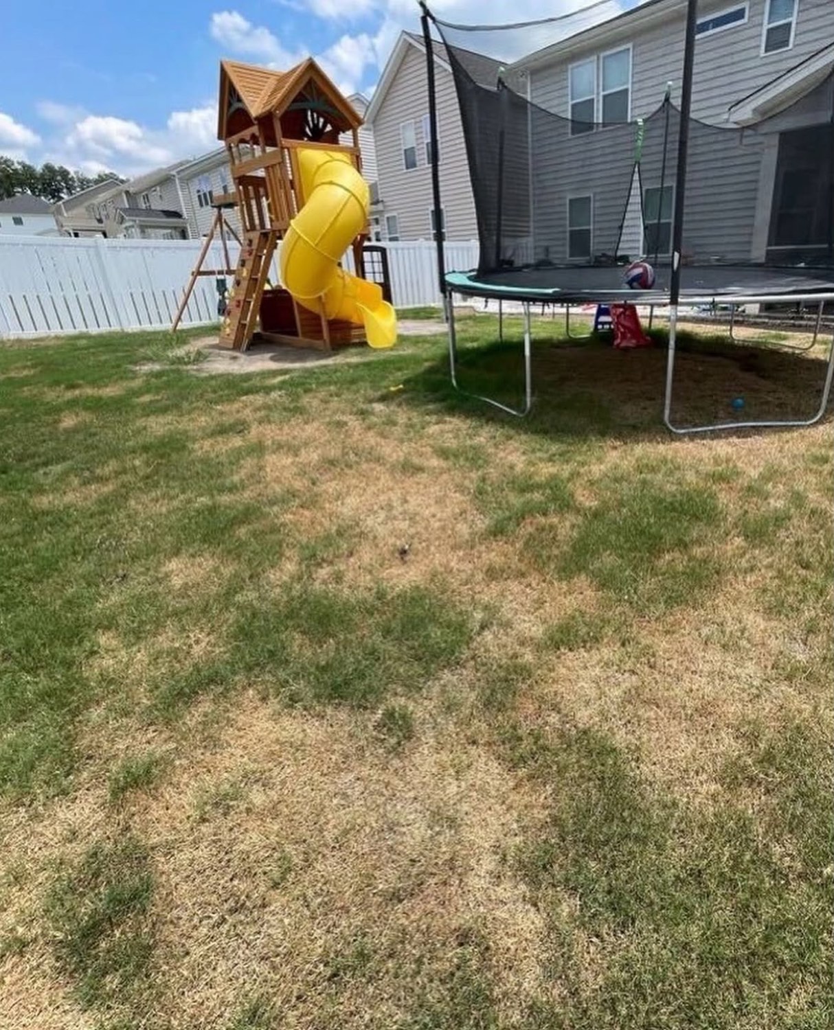 Patio de juegos con grama pelada antes de la instalación
