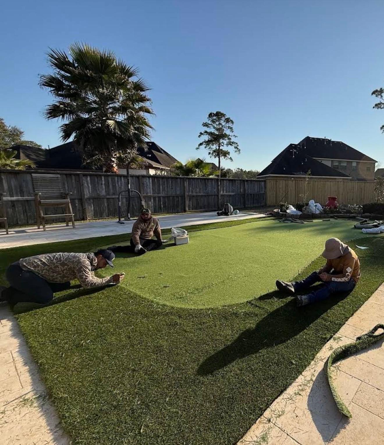 La cuadrilla de Turf Ventage instalando a mano un putting green de grama artificial en Houston