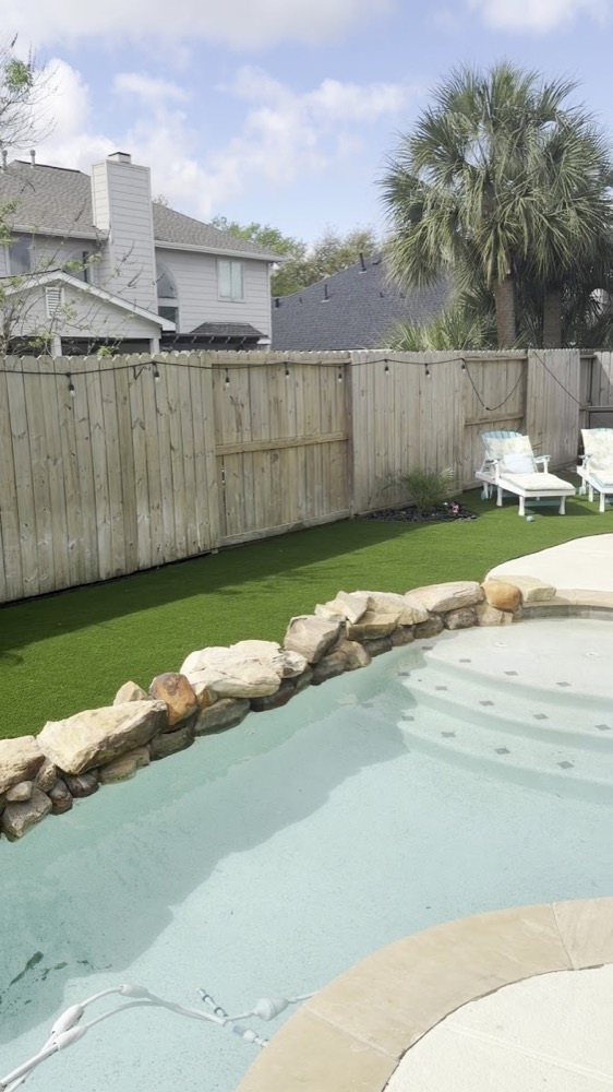 Grama artificial junto a piscina con palmera, Houston